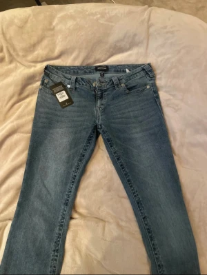 Bootcut jeans - Sååå snygga blå jeans med rosa sömmar från true religion med prislappen kvar, de är i strl w30 och har rosa sömmar. Säljer de då jag fick de i julklapp men tyvärr så passade dem inte mig. Skriv för frågor, mått, bilder eller prisförslag! Kan tänka mig gå ner i pris vid snabb affär. 