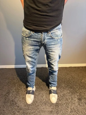 Dondup jeans - Säljer ett par trendiga Dondup jeans med snygga slitningar och tvättade detaljer. De har en slim passform. Storlek 31. Modellen på bilden är 184.