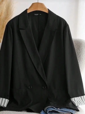 Svart kavaj med randiga muddar - Stilren svart kavaj med klassisk krage och två knappar framtill. Ärmarna har uppvikta muddar med gråvita ränder som ger en cool kontrast. Perfekt för dig som vill ha en enkel men snygg look. Passar till jeans eller kostymbyxor.