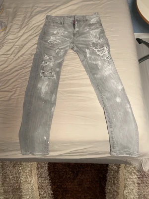 Grå slitna jeans från Dsquared2 - Säljer ett par grå jeans från Dsquared2. Har används väldigt sällan, storlek 32.