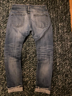 Earnest Sewn Selvedge jeans - Extremt snygga 19 åriga selvedge jeans från Earnest Sewn. Fadsen är fenomenala. En skygg lagning på ena knäet. Passformen är straight/slim. Fina detaljer slm en selvedge ID runt midjan och back taben av metall. Extremt unika och sällsynta jeans.  Måtten är 41cm bredd (sida till sida i midjan), 81cm innersöm, 104cm yttersöm. Skriv vid funderingar. 