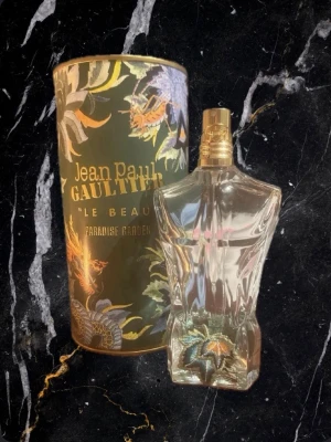Söker byten Jean Paul Gaultier Le Beau Paradise  - Snygg och unik parfym med tropisk design från Jean Paul Gaultier. Flaskan har coola detaljer och kommer i en färgstark förpackning med Paradise Garden-tema. Perfekt för dig som vill sticka ut med din stil.