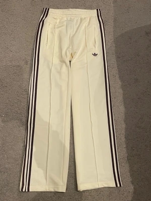 Adidas mjukisbyxor med bruna ränder - Adidas firebird byxor helt oanvända!! Prislapp finns kvar. Köptes för 800kr