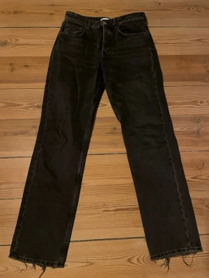 Svarta raka jeans från Zara  - Säljer ett par svarta jeans med rak passform Jeansen har klassisk femficksdesign och knappgylf. Perfekta för dig som gillar en avslappnad och trendig look. 