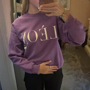 Lila LÈON sweatshirt  - Säljer en lila tröja från Gina tricot med vitt tryck framtill. Tröjan har rund halsringning och långa armar. 