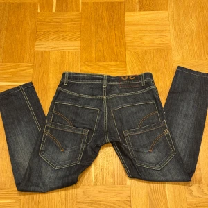 Mörkblå jeans från Dondup - Snygga mörkblå jeans från Dondup med kontrastsömmar och unika bakfickor med dekorativa detaljer. Jättebra skick. Hör av er vid frågor eller funderingar. Pris kan gå ner vid snabb affär.