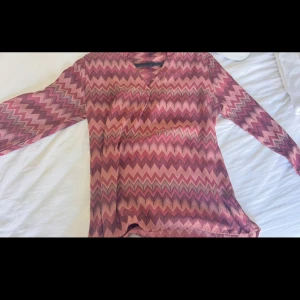 Rosa/lila missoni topp  - Säljer en skit snygg missoni blus som är långärmad och v-ringad. Materialet är som de flesta blusar. Be gärna om bild på!🩷pris kan även diskuteras då det är min mammas som hon ej använder och bara vill bli av med
