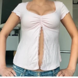 Rosa söt topp med spets - Supersöt ljusrosa topp från Gina Tricot med urringning, spetskant och slits framtill. Materialet är jätte mjukt, stretchigt och bekvämt. Och tröjan är i nyskick då jag endast provat den men aldrig använt den. Bild 2 och 5 är lånad men visar hur tröjan sitter på och bild 1 är i samma färg💛