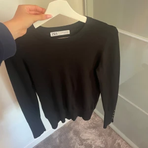 Svart tröja  - Supersnygg svart tröja från Zara. Knappt använd då den ej är min stil. Passar både till vardags o fest. Inga större defekter, den har endast lite textilfiber. Den har också fyra knappar på varje handled, se bild 3. Hör av er om ni har frågor ❤️