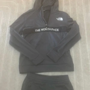 Svarta mjukisbyxor från The North Face - Snygga svarta mjukisbyxor från The North Face med logga på låret. Byxorna har elastisk midja, raka ben och är gjorda i ett mjukt och bekvämt material. Perfekta för chill eller träning. Matcha med hoodie för en komplett look.
