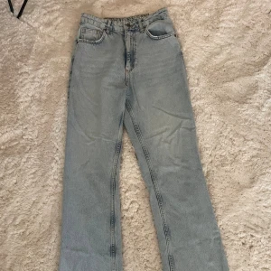 Ljusblå jeans med slits från Never Denim - Ljusblå raka jeans från Bik Bok med hög midja och slitna benslut. 