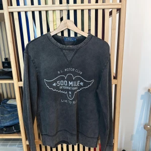 Sweatshirt Polo Ralph Lauren storlek S - Sweatshirt Polo Ralph Lauren storlek S.        Snygg sweatshirt från Polo Ralph Lauren med vintage tvätt och tryck på bröstet: 'R.L. Motor Club 500 Mile International'. Långärmad modell i mjuk bomull med ribbade muddar och klassisk rund hals. Storlek small och i väldigt fint skick. 