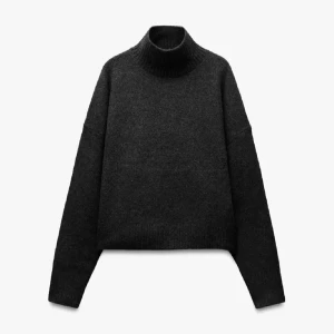 Mörkgrå polotröja i ullmix - Snygg mörkgrå polotröja med hög krage och lång ärm. Tröjan är stickad i mjuk ullmix och har en loose passform som ger en chill vibe. Perfekt att styla med jeans eller kjol för en enkel men trendig look. Aldrig använd 