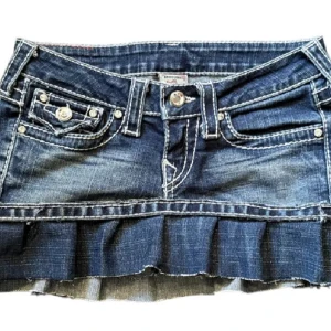 True Religion jeanskjol med volang - Snygg kort jeanskjol från True Religion med volangkant nertill och markerade vita sömmar. Jääättefin och cool, passar nu till hösten, säljer då jag har en liknande!