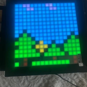 PIXOO Pixel Art Drawing Board - PIXOO är en interaktiv pixel art-ritbräda där du kan skapa och visa egna digitala konstverk. Perfekt för dig som gillar retrospel, kreativt skapande och vill ha en cool inredningsdetalj. Styr via appen och välj bland tusentals pixelbilder eller skapa egna! Helt ny. 