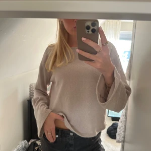 Beige stickad tröja med vida ärmar - Säljer en beige stickad tröja från H&M med långärmade och lite vidare ärmar. Tröjan har en enkel, rak passform och är gjord i mjukt stickat material. Perfekt för dig som gillar en clean och chill stil. Slutsåld överallt!