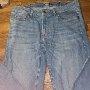 Ljusblå jeans från Dressmann 33/30 - Snygga ljusblå jeans från Dressmann i klassisk femficksmodell. Jeansen har raka ben, normal passform och är tillverkade i mjukt denimtyg. Perfekta för dig som gillar en enkel och stilren look.