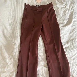 Bruna bootcut byxor från SHEIN - Snygga vinröda bootcut-byxor från SHEIN med pressveck och hög midja. 