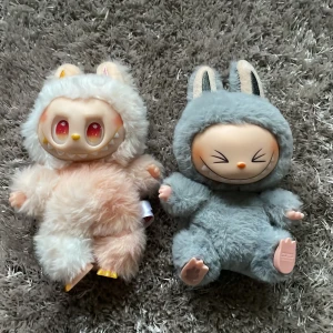 2 Labubus - Två unika och fluffiga labubus från THE MONSTERS-serien. Perfekta som samlarobjekt eller dekoration för dig som gillar söta och annorlunda monster. Med nyckelring för att enkelt fästa på väskan eller nycklarna. Passar dig som vill sticka ut!