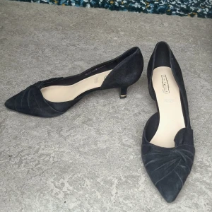 Svarta kitten heels i mocka - Svarta katten heels i mjuk mocka från 5th Avenue, köpt via Sellpy. Skorna har spetsig tå, låg klack med gulddetalj och snyggt vikt tyg framtill. Något för stora för mig, men så fina!✨️🎀