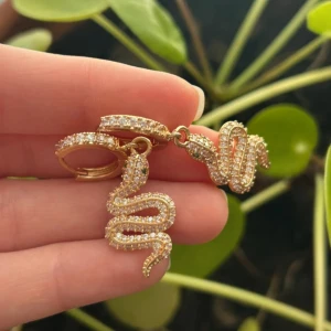 Hoops - Super coola hoops och med orm i strass. Ögonen är små gröna strass. Köpta från en liten butik i Göteborg för länge sedan för 500kr. Aldrig använda, endast provade. Används inte då jag använder silversmycken.  Osäker på material. Men då dom bara legat hemma och inköpta för ca 2 år sedan och fortfarande ser ut som nya skulle jag gissa på stainless steel.  Allt ska bort, har bundle rabatt. Kom med prisförslag🥰🥰