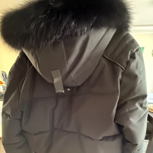 Svart pufferjacka från Horspist Paris - Snygg svart pufferjacka från Horspist Paris med stor huva och fluffig pälsimitation. Jackan har flera dragkedjor framtill, markerade sömmar och en patch på ärmen. . Pälsen går att ta av. Köpt av Trelupi, använd endast en vinter. Väldigt bra skick. Storlek XL (fransk storlek) passar egentligen L, funkar även på M. Priset är redan bra och kan eventuellt gå ner någon hundring. Inga byten. Kan mötas upp.