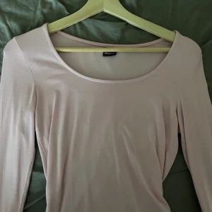 Ljusrosa långärmad topp Gina Tricot - Säljer en ljusrosa långärmad topp från Gina Tricot. Toppen har en rundad, bred urringning och är gjord i ett mjukt, stretchigt material som sitter snyggt på kroppen. Perfekt att styla med jeans eller kjol för en clean look.