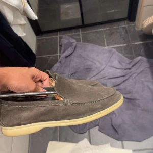 Bruna Loro piana  mockaloafers - Snygga loros i brun mocka med stilren design. Perfekta för dig som gillar en clean och avslappnad look. Skick 9/10 allt OG ingår. Storlek 41/42