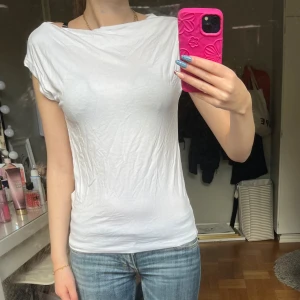 Vit ärmlös topp  - Enkel och stilren vit topp med ärmlös design och rund halsringning. Tillverkad i mjuk bomull som känns skön mot huden. Perfekt att matcha med jeans eller kjol för en clean look.