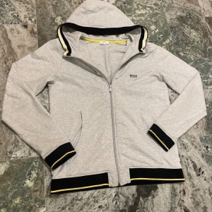 Grå Hugo Boss zip hioodie - en stilren hugo boss hoodie i en fin färg. Intresserad? Kom gärna med bud skriv privat om frågor mm