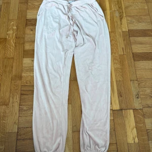 Ljusrosa mjukisbyxor från Isabella S - Supermjuka ljusrosa mjukisbyxor från Isabella i storlek S. Byxorna har resår i midjan med snörning, fickor med söt spetsdetalj och är gjorda i ett mysigt fleecematerial. Perfekta för chill dagar hemma.