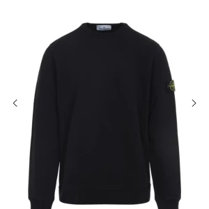 Svart sweatshirt från Stone Island - Svart sweatshirt från Stone Island med klassisk rund hals och lång ärm. Tröjan har den ikoniska logotypen på vänster ärm och är tillverkad i mjuk bomull. Perfekt för en clean och stilren look.