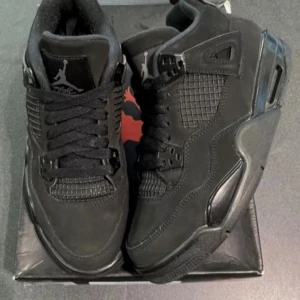 Nike Air Jordan 4s priset går att diskuteras  - Säljer ett par svarta Nike Air Jordan 4 Retro Black Cat sneakers. Skorna har en helsvart design med meshpaneler, mockadetaljer och klassisk Jumpman-logga på plösen. De har snörning och en chunky sula som ger en riktigt clean och stilren vibe.