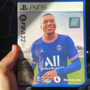 FIFA 22 PS5 - FIFA 22 till PlayStation 5 med Hypermotion-teknologi. Komplett med fodral och skiva i mycket gott skick. Upplev realistisk fotboll med officiella ligor och lag. Perfekt för fotbollsfans som vill ha den senaste generationens spelupplevelse.