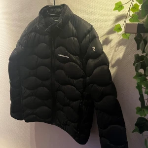 Svart dunjacka Peak Performance 170 - Lite tunnare peak dunjacka. 👍Riktigt snygg och en bra lite lättare jacka för vinter/höst. ❄️🍂 Anledningen till det låga priset är två små lappade hål som knappast syns 