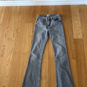 Grå bootcut jeans från ONLY, M/32 - Snygga grå jeans från ONLY i bootcut-modell med klassiska fem fickor och dragkedja. Jeansen har en medelhög midja och är tillverkade i mjukt denimtyg med lite stretch för extra komfort. Perfekta för dig som gillar en retroinspirerad look.