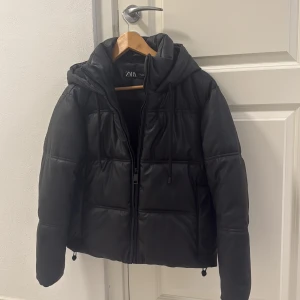 Svart pufferjacka i skinnimitation Zara XS - Vinterjacka från Zara!! Super bra skick!! Har använts en vinter och är i jätte bra skick den är jätte varm och kan till och med användas nu på hösten när det är så kallt, priset går att diskutera!❤️ finns inga defekter!