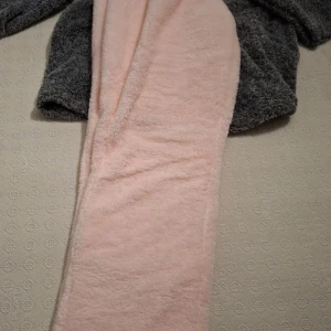 Fluffiga ljusrosa mjukisbyxor - Supergosiga ljusrosa mjukisbyxor i fleece med resår i midjan. Perfekta för att chilla hemma eller mysa runt i. Byxorna har en loose passform och är riktigt mjuka och varma. Snyggt att matcha med en hoodie eller oversized tröja.