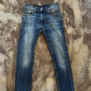 Nudie Jeans - Säljer nu min sjukt feta Nudie jeans, med galen fade. Jeansen har en ganska tajt passform, och passar dig mellan 155-165. Jeansen har en sjuk tvätt - de är selvedge jeans. Jeansen är inte i bra skick, kolla bild 3,4 och 5, därför är också priset så pass billigt. 