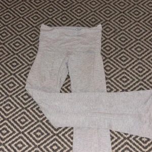 Grå bootcut mjukisbyxor - Snygga grå yoga pants med bootcut-ben. Man kan vika ner byxorna så de kan vara både högmidjade och lågmidjade. Byxorna är tillverkade i mjukt bomullsmaterial och har en bred linning som ger extra komfort. Perfekta för en avslappnad och chill stil.