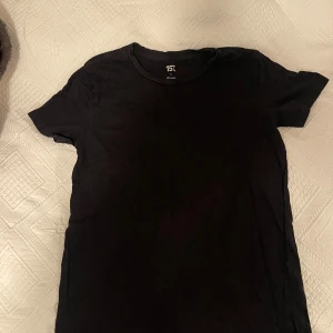 Svart basic t-shirt  - Enkel svart t-shirt från lager 157 i klassisk modell. T-shirten är tillverkad i mjuk bomull och har rund halsringning och korta ärmar. Perfekt basplagg