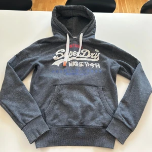 SuperDry hoodie - Grå SuperDry Hoodie Storlek M Skicket är 8/10  Hör av dig vid frågor och funderingar