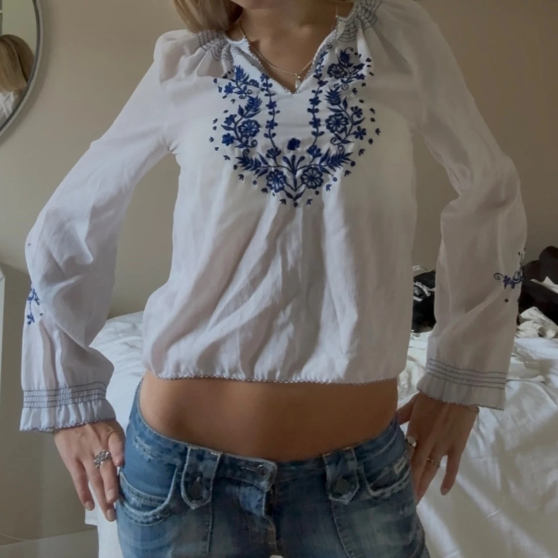 Vit blus med blå broderi