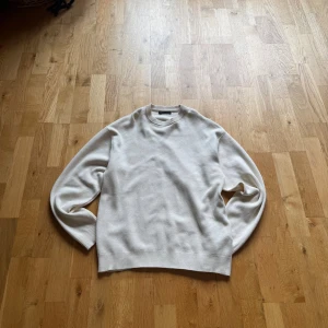 Beige stickad tröja från Zara - Säljer en stilren beige stickad tröja från Zara i storlek S. Tröjan har rund halsringning, ribbade muddar och lång ärm. Perfekt för lager-på-lager och enkel att matcha med jeans. Använd en gång. Nypris ca 500kr