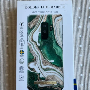 Golden Jade Marble Case for Galaxy S9 Plus - Stilrent mobilskal med marmor-design i grönt och guld, speciellt utformat för Samsung Galaxy S9 Plus. Skalets tunna och lätta konstruktion ger ett elegant utseende och skydd mot repor och stötar. Passar trådlös laddning och har svensk design. Skicket är nytt i originalförpackning.