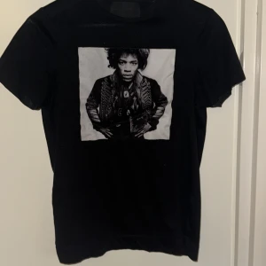 Svart t-shirt med Jimi Hendrix-tryck Limitato Storlek XS - Svart t-shirt från Limitato med ett stort svartvitt tryck av Jimi Hendrix på bröstet. Klassisk rund hals och korta ärmar. T-shirten är gjord i mjuk bomull och har en clean look med fokus på det ikoniska motivet framtill. Storlek XS och använd 1 gång! Limited edition finns få!