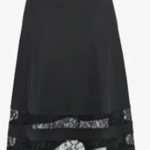 Svart a-linjekjol i storlek 38 från Anna Field - Svart knälång a-linjekjol från Anna Field i storlek 38. Kjolen är med resår i midjan och dekorativ spetsdetalj nedtill. Kjolen har en utsvängd modell.