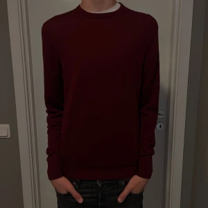 Vinröd stickad tröja från Uniqlo - Säljer en vinröd stickad tröja från Uniqlo i storlek S. Tröjan har rund halsringning och långa ärmar, perfekt för dig som gillar en enkel och stilren look. Materialet är mjukt och passar bra till både jeans och chinos.