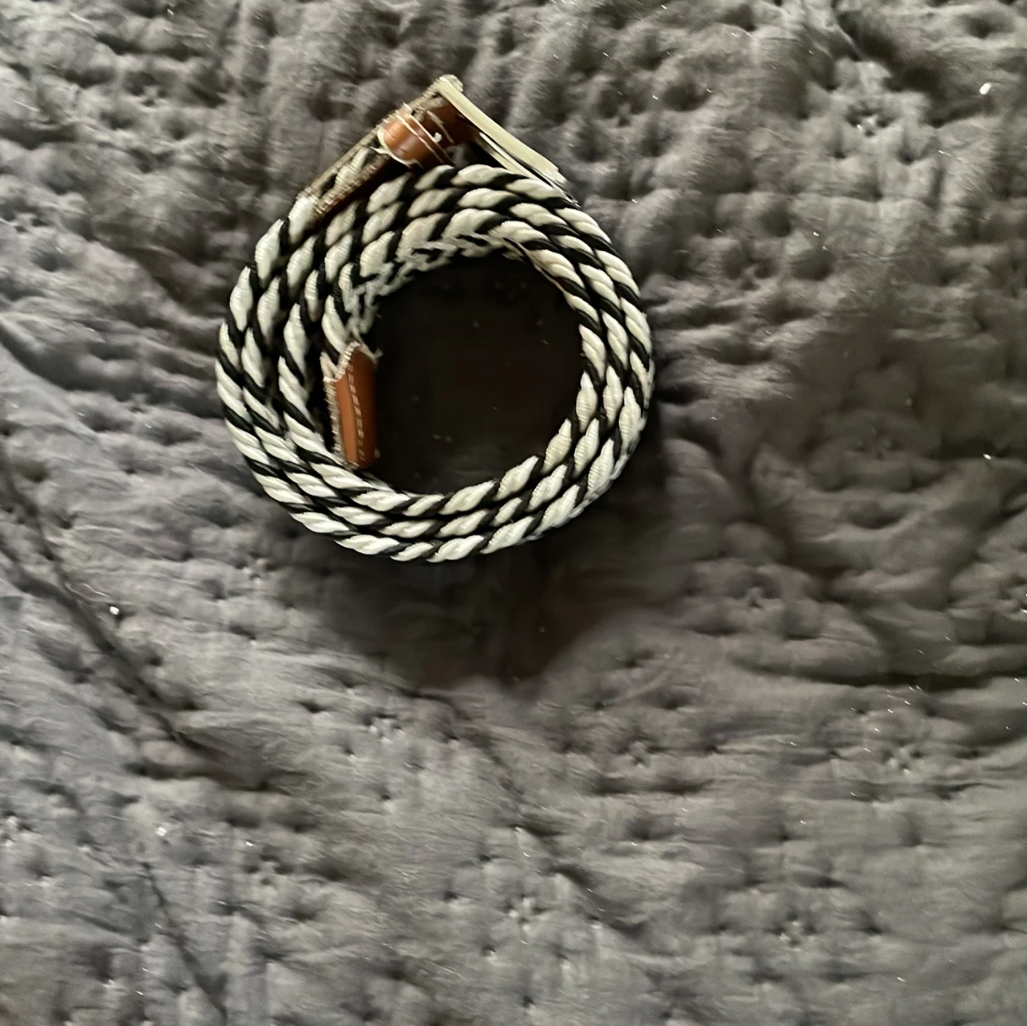 Randigt flätat bälte med läderdetaljer