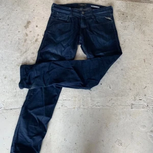 Replay mörkblå jeansbyxor 30/32 - Säljer ett par snygga mörkblå jeans från Replay i klassisk femficksmodell. Jeansen har raka ben och normal passform, tillverkade i slitstarkt bomullsmaterial. Perfekta för dig som gillar stilrena och tidlösa jeans.
